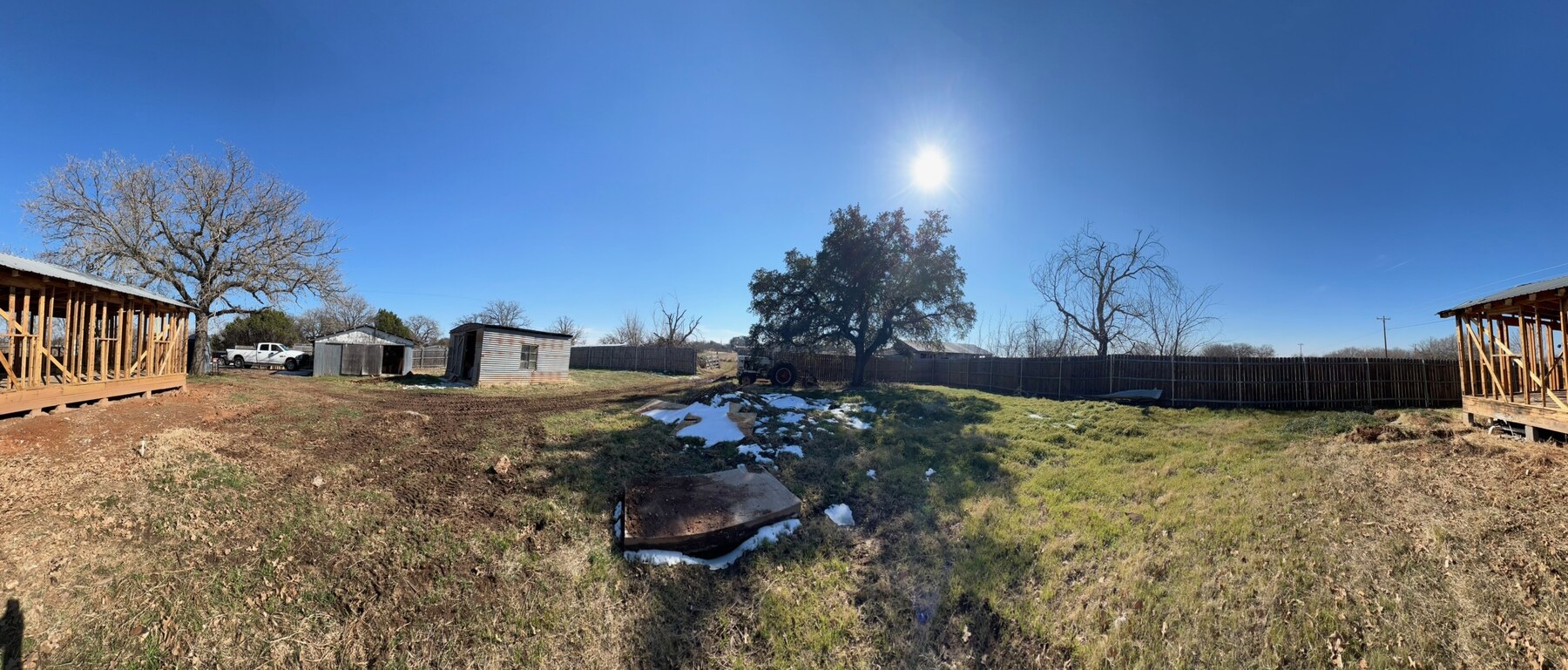 Wide view of the one-acre Lipan property with visible framing, yard, fencing, and trees